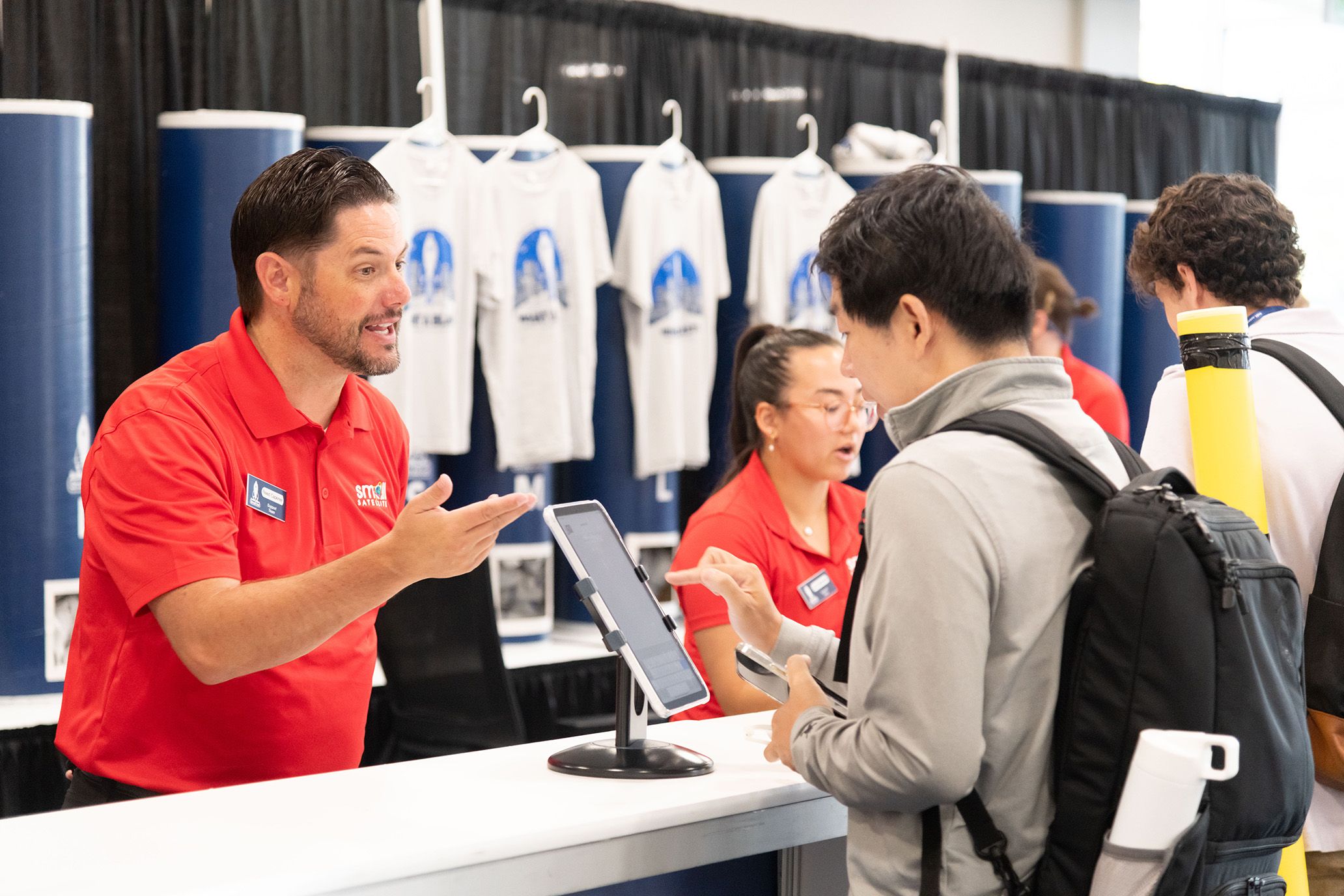 Conference attendee being greeted by a SmallSat team member.
